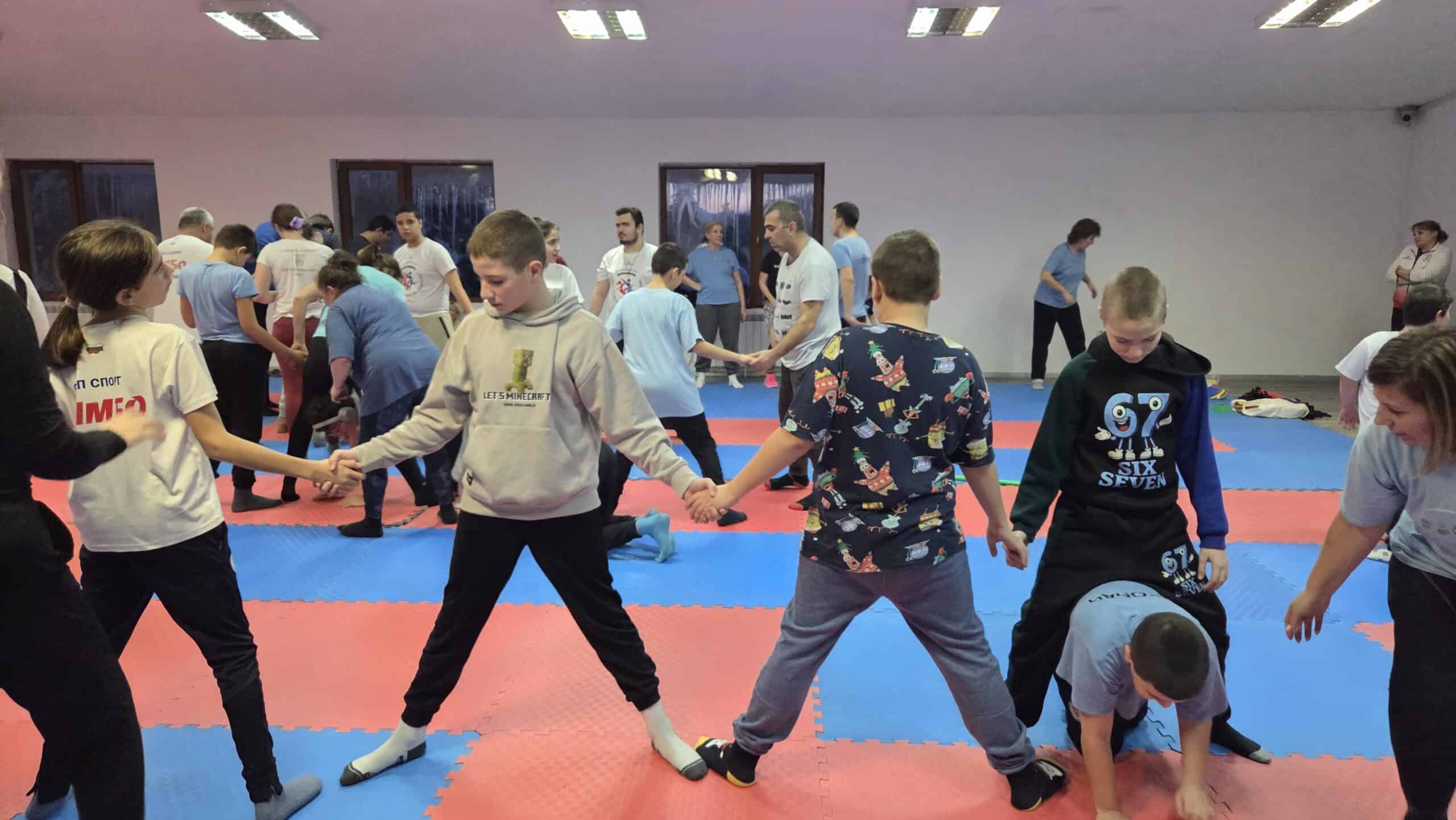 Деца практикуват самбо в тренировъчна зала за развитие и спорт.