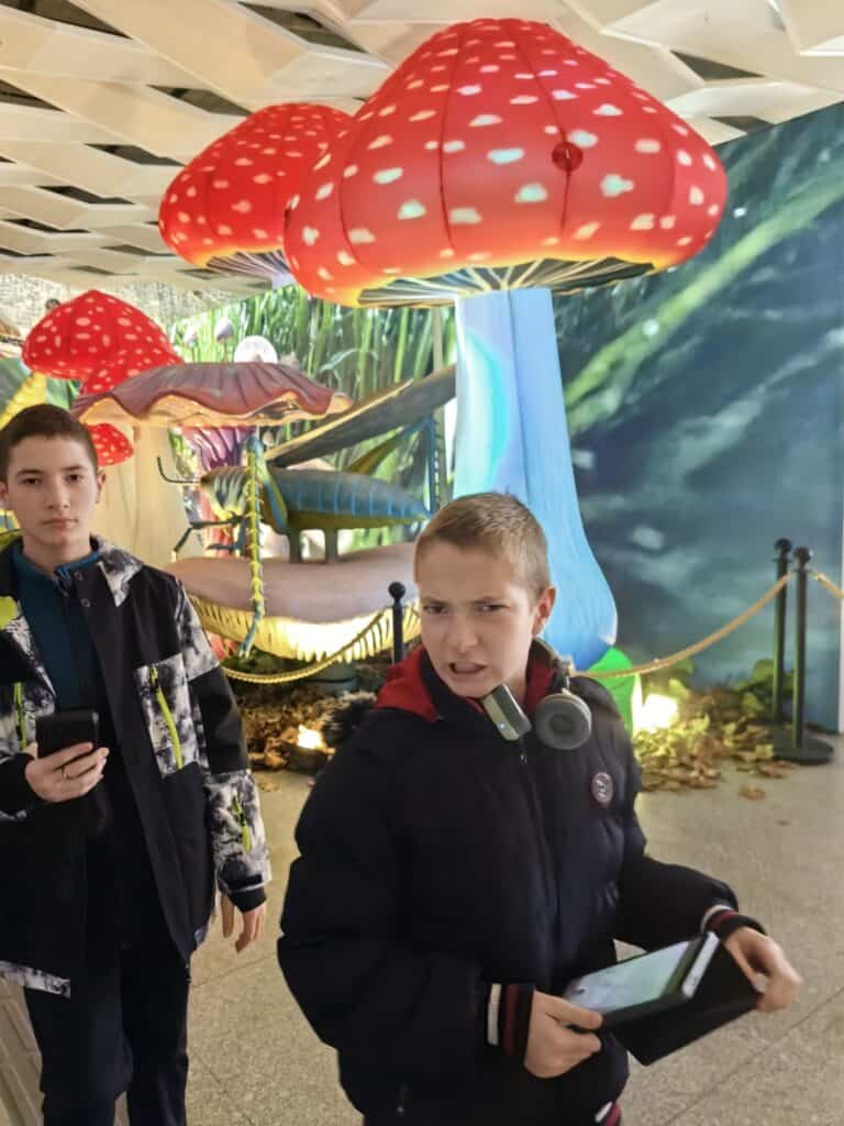 Деца в музей с големи декоративни гъби и насекоми, вдъхновяващи за развитие и творчество.